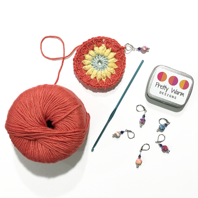 Crocheted centre for Sunburst Granny Square with crochet hook and Pretty Warm Designs crochet stitch markers
