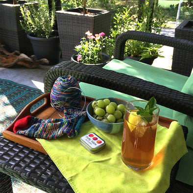 Outdoor patio with iced tea, grapes, chair and planters, sock knitting by Pretty Warm Designs 