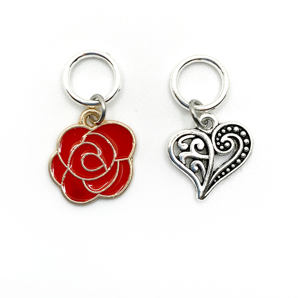 Two Valentine's Day themed knitting ring stitch markers, one red rose and one Tibetan antiqued silver filigree heart by Pretty Warm Designs