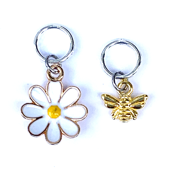 Two summer-themed knitting ring stitch markers, one yellow and white enamel daisy and one gold toned honeybee by Pretty Warm Designs