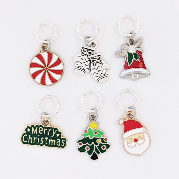 Set of 6 metal alloy and enamel Christmas stitch markers, ring style for knitting. Includes "Merry Christmas", peppermint, Christmas tree, Santa, Mittens, and Bell