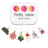 Set of 6 metal alloy and enamel Christmas stitch markers with storage tin, ring style for knitting. Includes "Merry Christmas", peppermint, Christmas tree, Santa, Mittens, and Bell