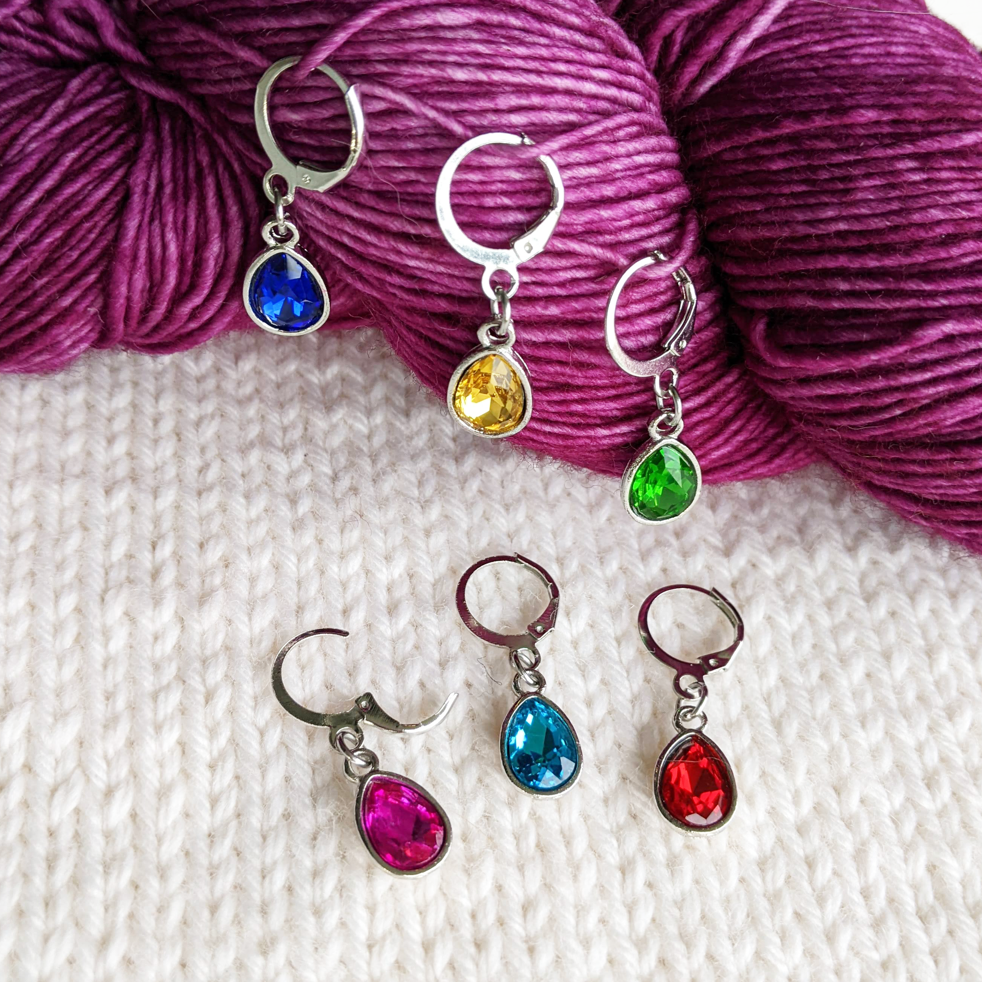 Crystal Jewels set of 6 gem coloured stitch holders with storage tin by Pretty Warm Designs, shown on worsted weight yarn