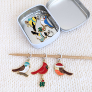 Open silver tin holding Christmas bird stitch markers