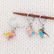 A Bird In the Hand Locking Stitch Markers, set of 3 colorful 3D bird charm markers for knitting or crocheting, shown on knitting needle