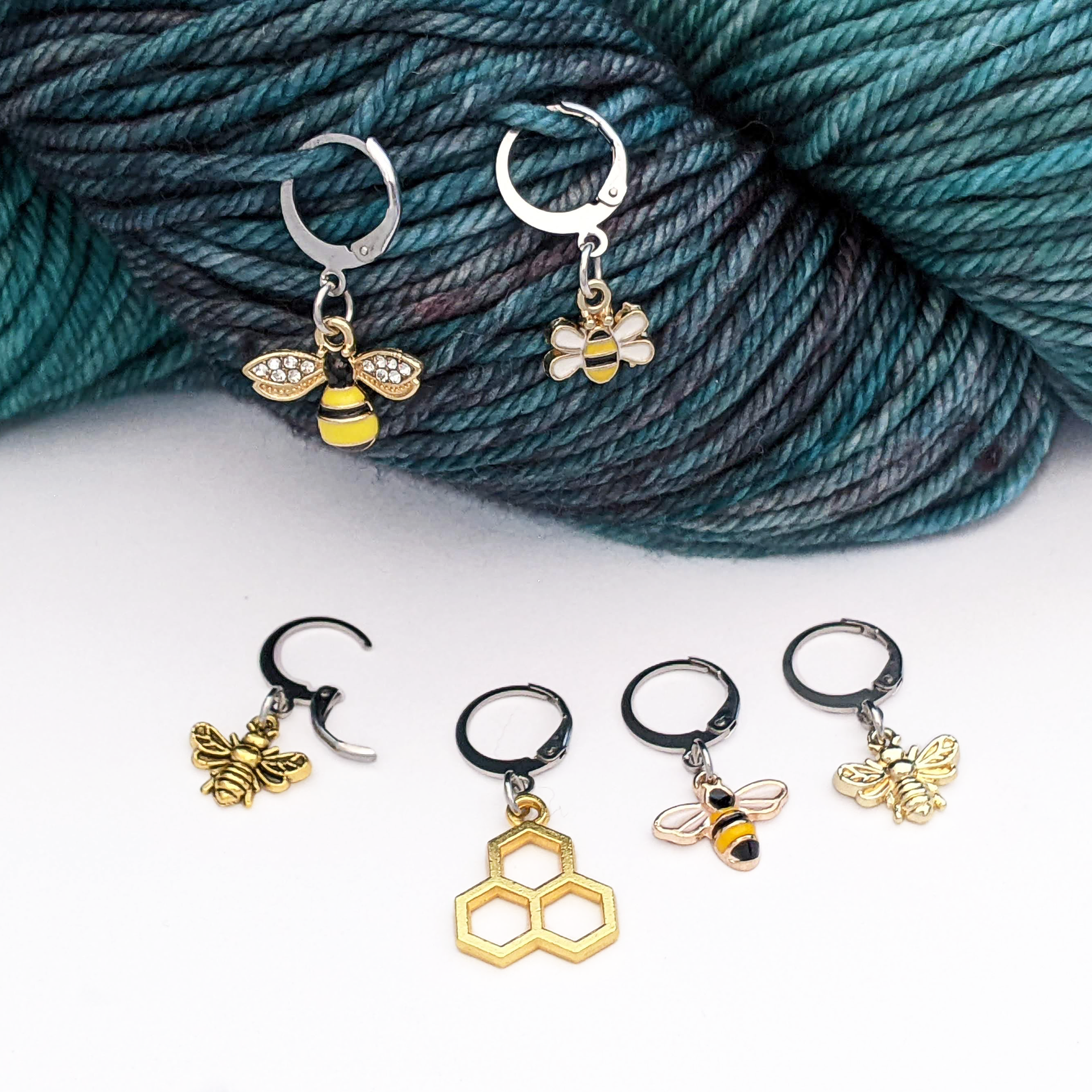 Set of 6 bee themed enamel charms locking crochet stitch markers for crochet shown on worsted weight yarn by Pretty Warm Designs