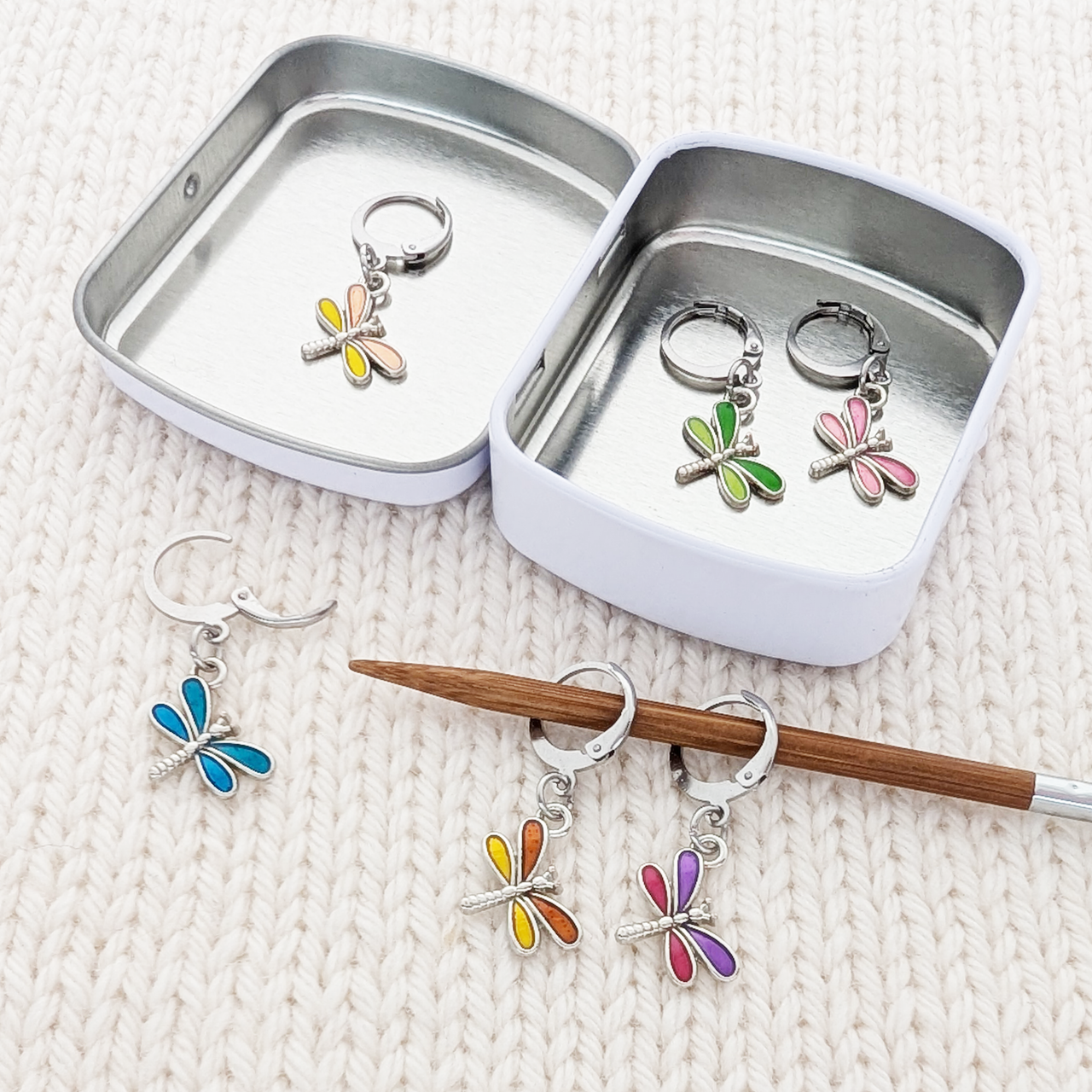 Dragonfly Locking Stitch Markers set of 6, shown on knitting needle, with storage tin by Pretty Warm Designs