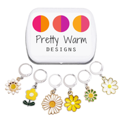 Set of six white, yellow and green enamel metal daisy charms with lever back clasps stitch markers for crochet and decorative tin with logo by Pretty Warm Designs