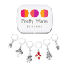 Set of five antiqued silver charm crochet stitch markers and one enamel toadstool charm locking crochet stitch markers with decorative Pretty Warm Designs logo tin for crochet by Pretty Warm Designs