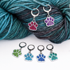 Set of six blue, light green, purple, turquoise, dark green and pink paw print pet charms on lever back clasps stitch holders shown with yarn for crochet by Pretty Warm Designs