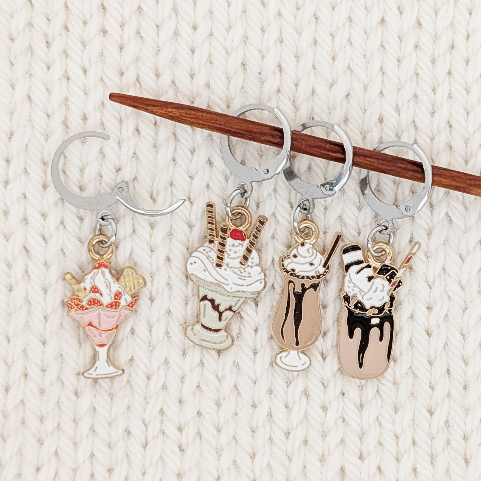 Set of 4 Ice Cream Sundae Locking Stitch Markers for crochet or knitting by Pretty Warm Designs, shown on a knitting needle with an open clasp