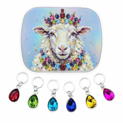 A square compact-style case with rounded corners featuring a colorful illustration of a sheep wearing a jeweled crown and necklace, shown above six matching teardrop ring style gem stitch markers in red, green, blue, dark blue, yellow, and pink on a white background.