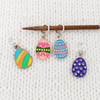 Set of 4 Easter Egg themed Metal Enamel Ring Stitch Markers for Knitting shown on a knitting needle