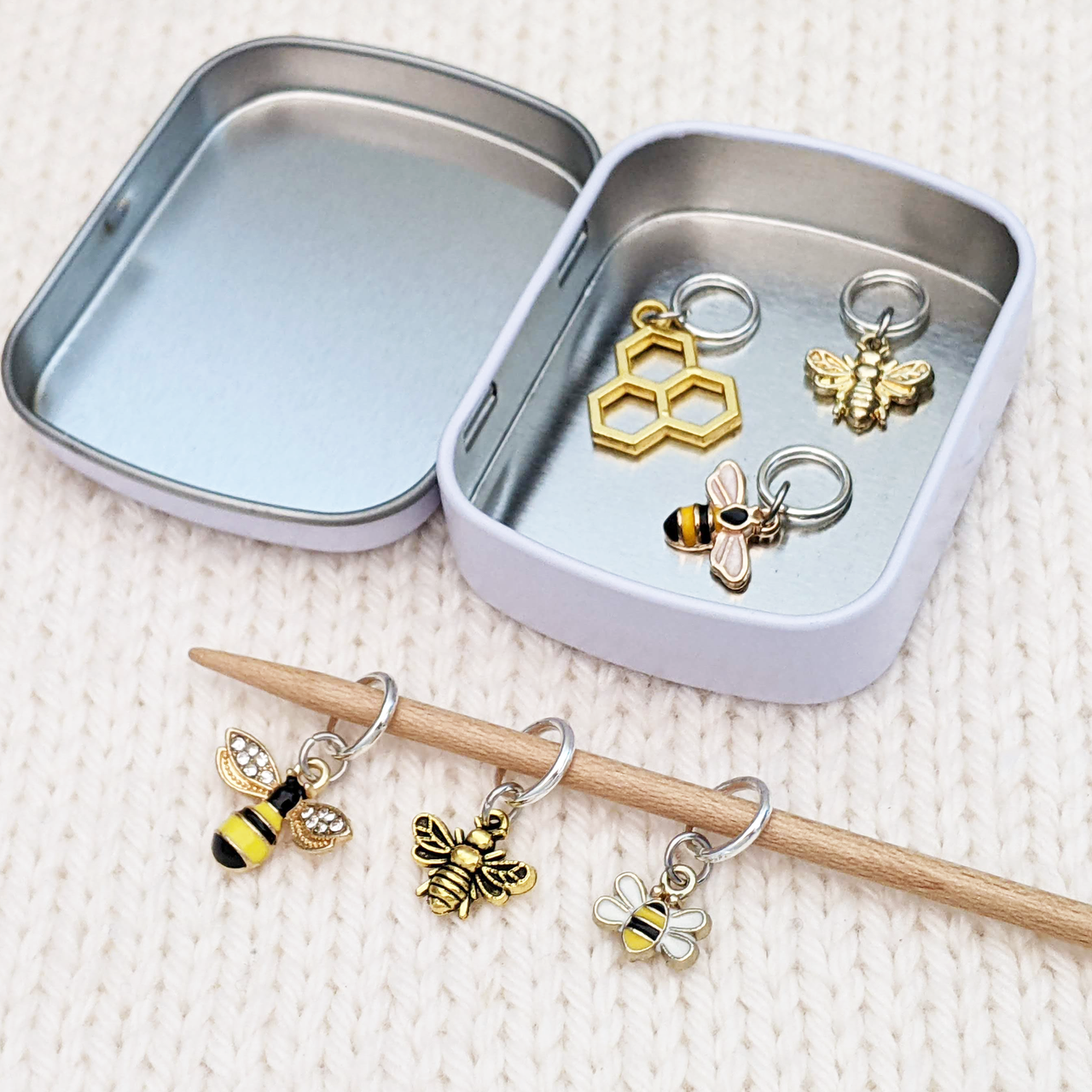 Set of six gold toned bee themed charms snag free ring stitch markers on needles with tin for knitting by Pretty Warm Designs