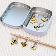 Set of six gold toned bee themed charms snag free ring stitch markers on needles with tin for knitting by Pretty Warm Designs