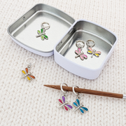 Set of 6 Dragonfly Ring Stitch Markers for Knitting including storage tin, shown on knitting needle, by Pretty Warm Designs