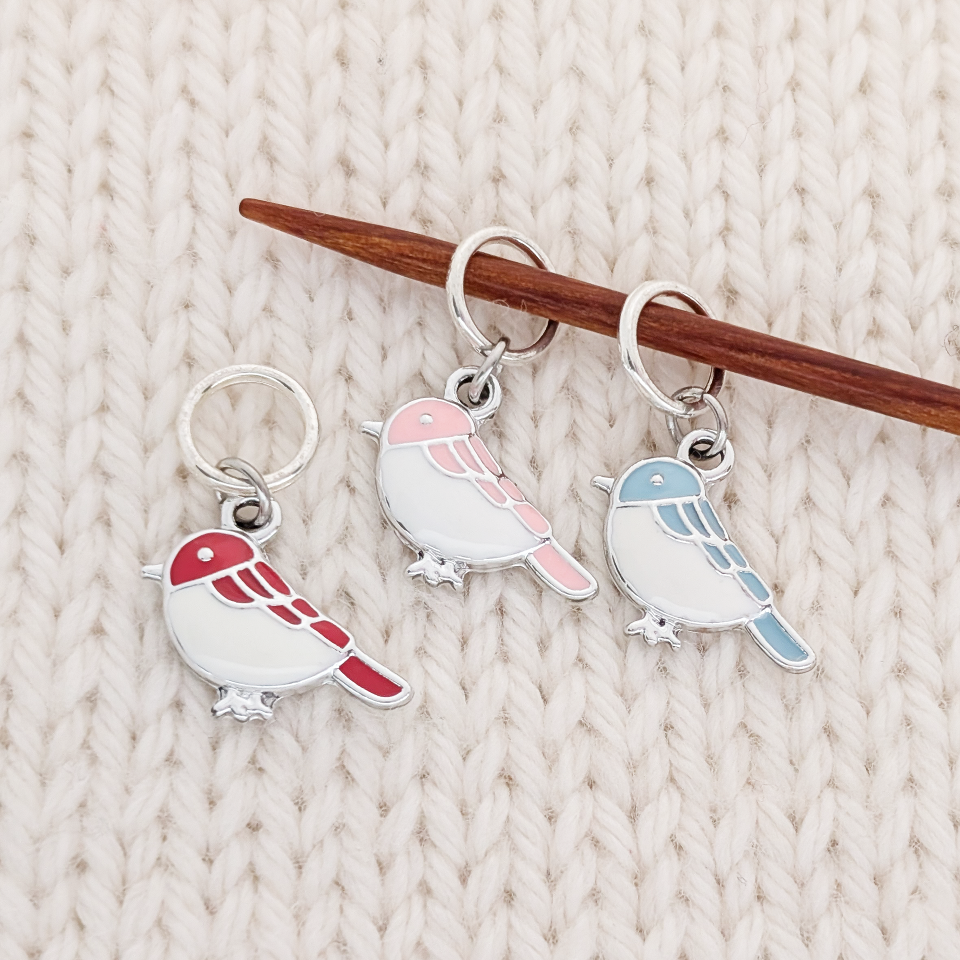 Set of 3 Birds of a Feather Stitch markers for knitting, ring style with red, blue, and pink bird charms, shown on a knitting needle