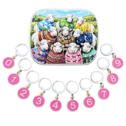 A set of locking stitch markers numbered 0 - 9 with a tin box. The tin box features a colorful illustration of nine sheep wearing vibrant, patterned sweaters in a landscape.