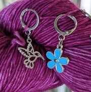 Hummingbird and Red Flower Locking Stitch Markers for Crocheting or Knitting shown on yarn skein