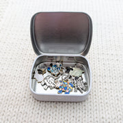 Pretty Warm Designs storage tin open showing six sheep knitting stitch markers — handmade gift for knitters