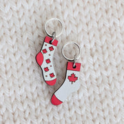 Close-up of Canadian-made Maple Leaf Socks knitting stitch markers handcrafted from basswood. The hand-painted sock-shaped charms feature smooth, silver-toned closed rings that easily slide over knitting needles up to US 8 (5mm).