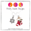 One red, white and green enamel with rhinestones Christmas stocking ring stitch marker and one silver alloy snowflake ring stitch marker for knitting with Pretty Warm Designs text and logo