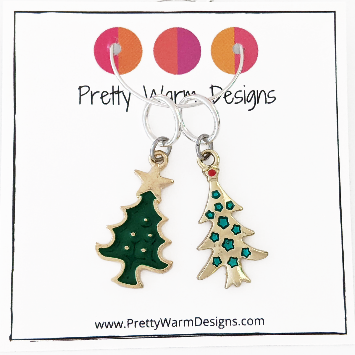Two Christmas tree ring stitch markers, one green with gold edging and one gold with stars