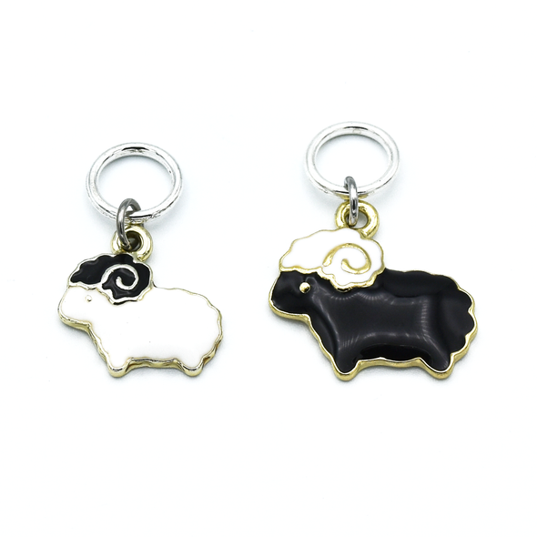 Two knitting stitch markers, one white sheep and one black sheep ring marker by Pretty Warm Designs