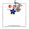 Two knitting stitch markers include one blue flower and one silver plated hand stamped with Hand Made charm attached with blue yarn to white cardstock printed with Pretty Warm Designs logo and text