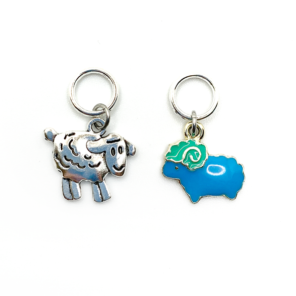 Two knitting ring stitch markers, one enamel blue and green sheep and one Tibetan antiqued silver lamb by Pretty Warm Designs
