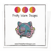 Pink, turquoise and yellow enamel on black background cat shaped yarn knitting pin by Pretty Warm Designs