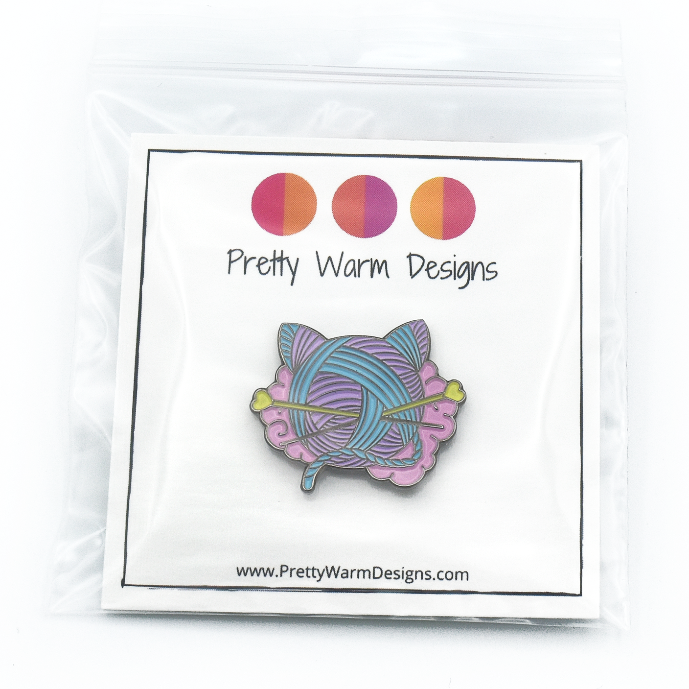 Packaged pink, turquoise and yellow enamel on black background cat shaped yarn knitting pin by Pretty Warm Designs