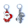 Two Christmas-themed knitting ring stitch markers, one red and white Santa with toy sack and one silver toned Christmas stocking by Pretty Warm Designs