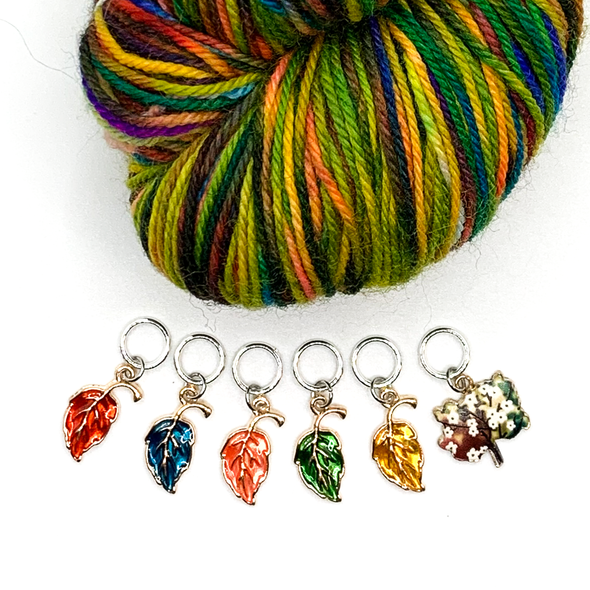 Set of five red, blue, orange, green and yellow enamel leaves and one tree charm snag free ring stitch markers with multicoloured yarn for knitting by Pretty Warm Designs