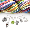Set of one green and yellow enamel daisy and five antiqued silver alloy gardening themed snag free ring stitch markers for knitting and multicoloured skein of yarn by Pretty Warm Designs Inc