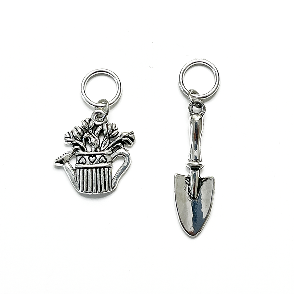 One antiqued silver alloy watering can holding flowers and one antiqued silver gardening trowel snag free stitch markers for knitting by Pretty Warm Designs Inc
