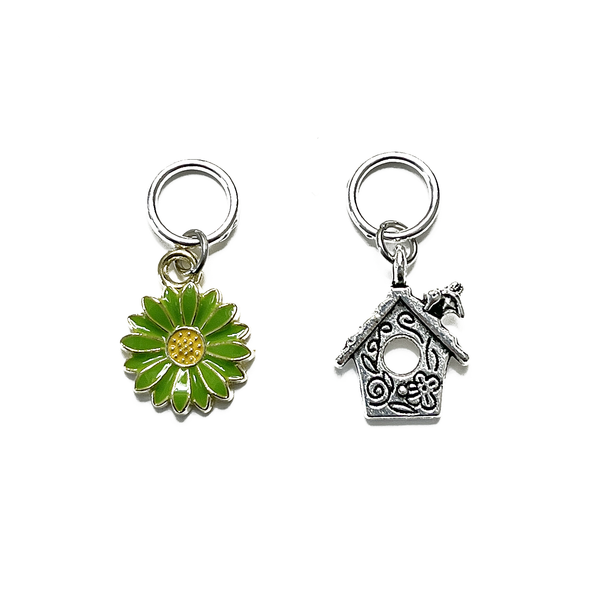 One green and yellow enamel daisy and one antiqued silver alloy bird house snag free ring stitch markers for knitting by Pretty Warm Designs Inc
