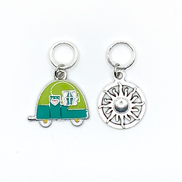 One two-toned green and silver enamel tiny camper and one antiqued silver sun symbol stitch markers for knitting by Pretty Warm Designs