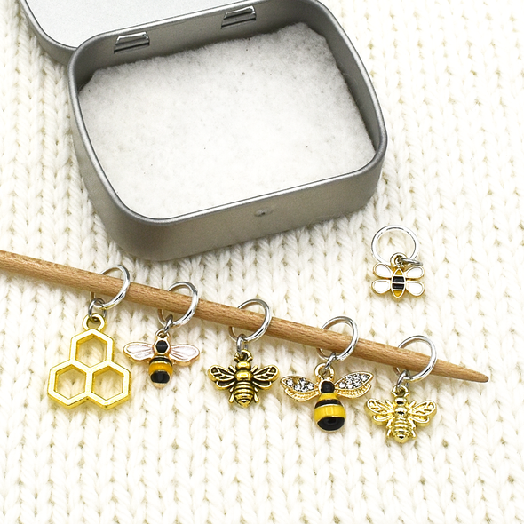 Set of six gold toned bee themed charms snag free ring stitch markers on needles with tin for knitting by Pretty Warm Designs