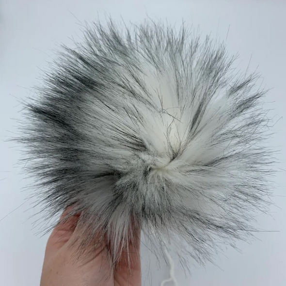 Handmade faux fur pompom held in hand by SweetBrieCreations for Pacific Northwest Christmas Yarn Box sold by Pretty Warm Designs Inc.