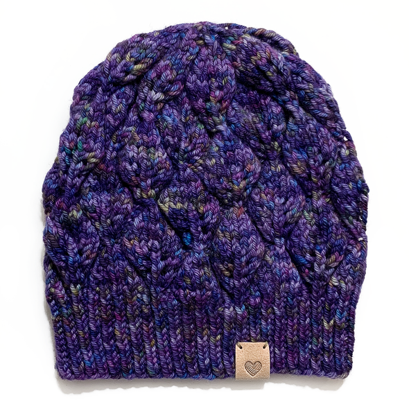 Tan PU polyurethane leather garment label tag sewn onto purple lace knitted hat, sold by Pretty Warm Designs Inc.
