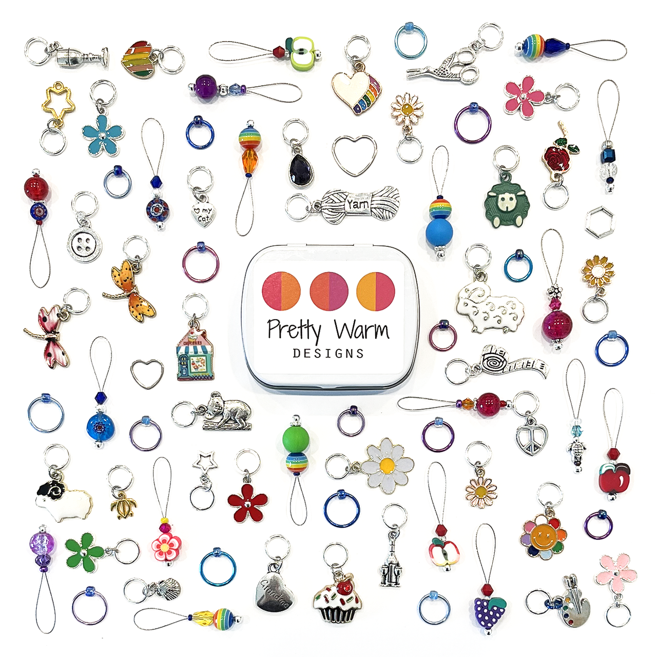 A wide assortment of colourful snag free stitch markers for knitting with a decorative storage tin by Pretty Warm Designs Inc