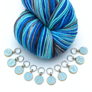 Set of ten blue on gold-toned number charm ring stitch markers with variegated yarn in blue colours for knitting by Pretty Warm Designs