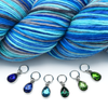 Set of six different coloured rhinestones in blues and greens set in silver toned snag free ring stitch markers for knitting by Pretty Warm Designs with blue and turquoise variegated yarn