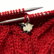 Sheep stitch marker on circular knitting needle — snag free ring style marker shown in use on cable knit project