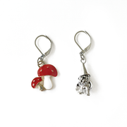 One red and white enamel toadstool crochet stitch marker and one antiqued silver gnome crochet stitch marker by Pretty Warm Designs Inc.