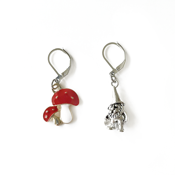One red and white enamel toadstool crochet stitch marker and one antiqued silver gnome crochet stitch marker by Pretty Warm Designs Inc.
