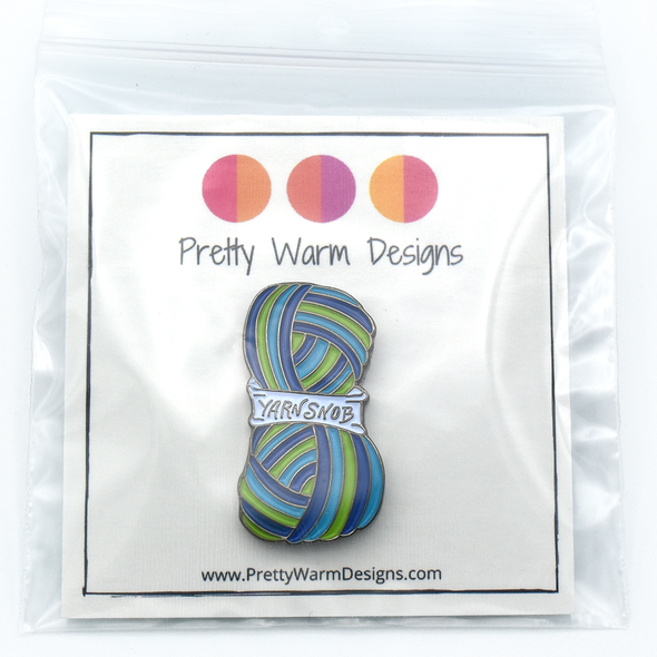 Packaged blue, green and white enamel on silver metal Yarn Snob pin for knitting and crochet project bags by Pretty Warm Designs
