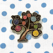 Multicoloured enamel on gold metal yarn tree pin on blue polka dot project bag by Pretty Warm Designs